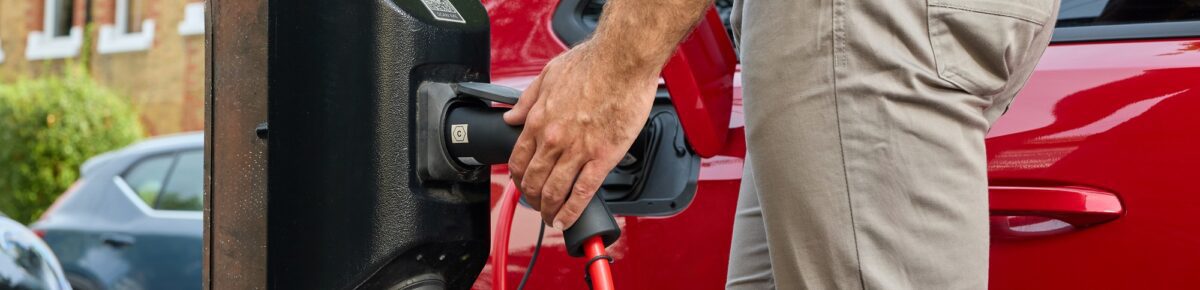 Plugging an electric car into a charging point