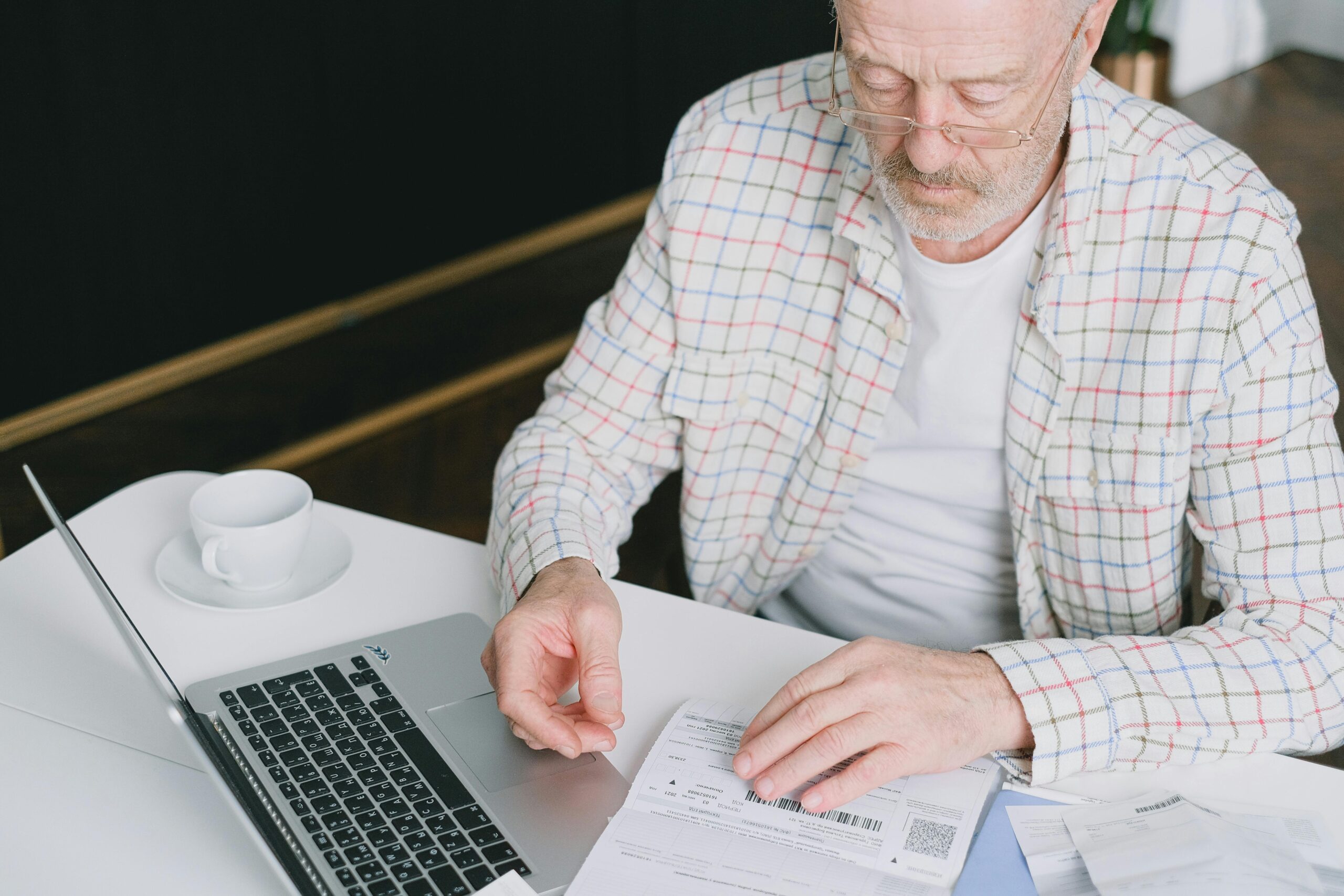 Pensioner looking at forms and working on a computor